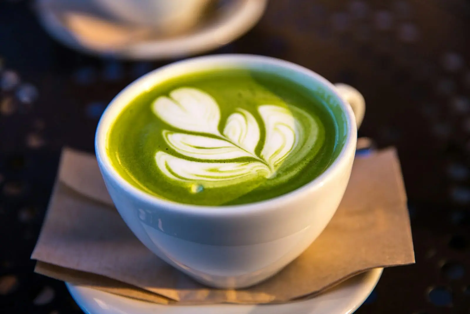 Matcha latte vert décoré d'une feuille de latte art