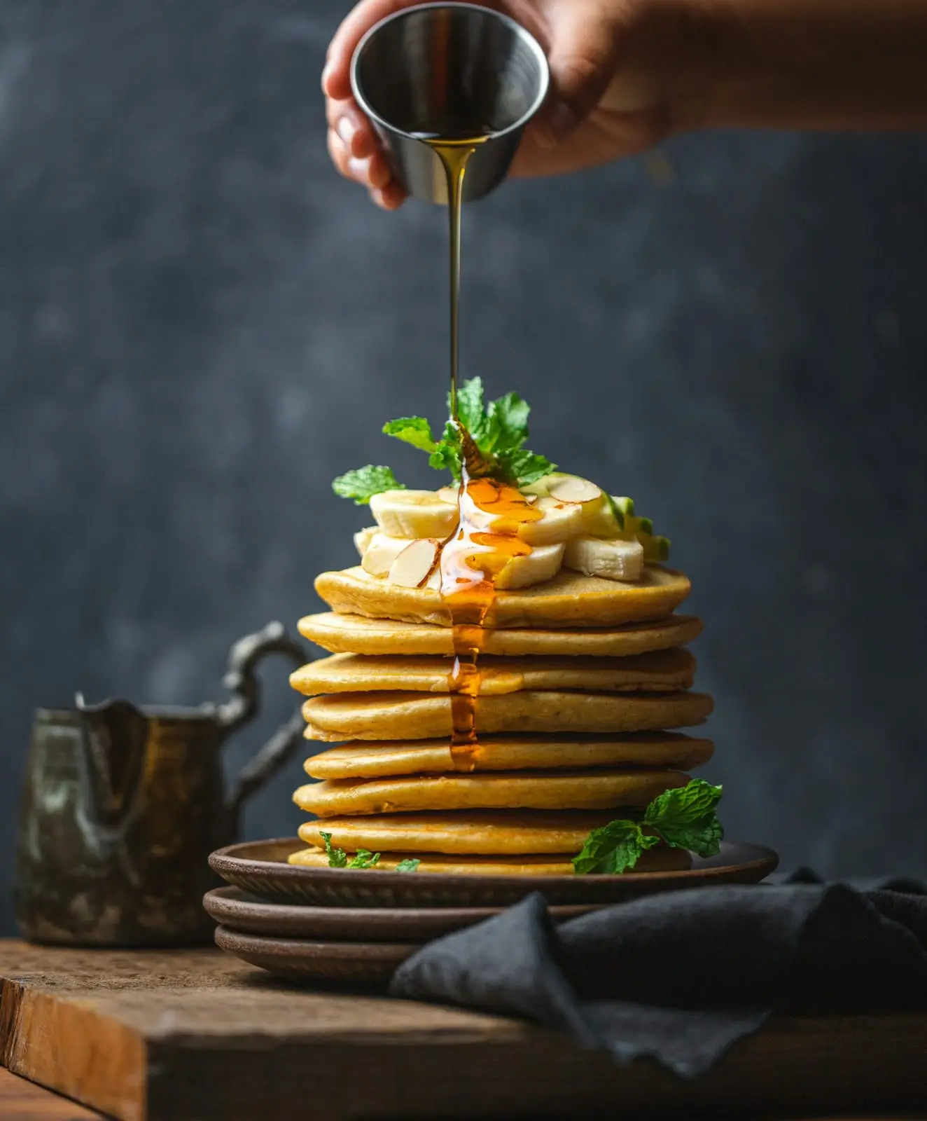 Pile de pancakes nappée de sirop et de banane